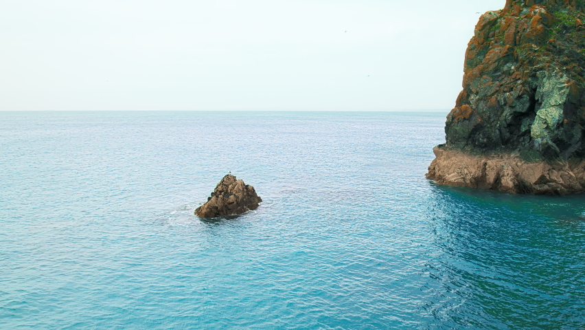 A seashore with big rocks formation, cliffs and blue waters from the Celtic Sea. Scenic Mullion Harbour, Helston, Cornwall, England in 4K. 