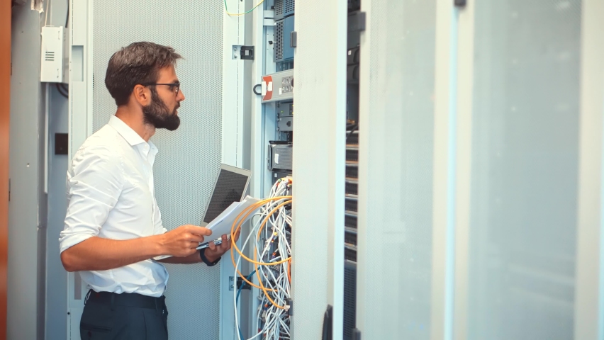 It Administrator Working In Server Room And Connecting Ethernet Wire. Communication Company Mining Network. Database Connection Hardware Cable. Mining Hardware Network.Backup E-commerce Server Hosting Royalty-Free Stock Footage #1075471340