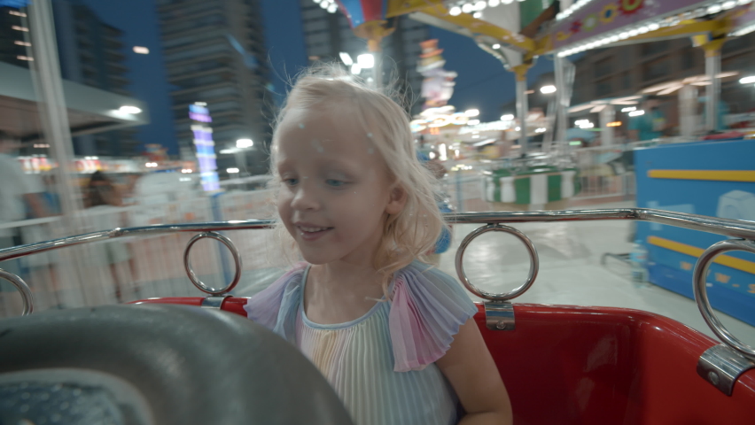 Excited little girl having fun in outdoor amusement park and riding on merry-go-round, view from inside the moving cart Royalty-Free Stock Footage #1075475855
