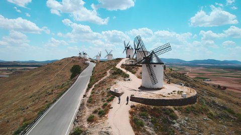 Drone point of view famous windmills in Consuegra town, symbol of Castilla-La Mancha, against fluffy cloudy sky background. History and heritage in Toledo concept. Europe, Toledo. Spain