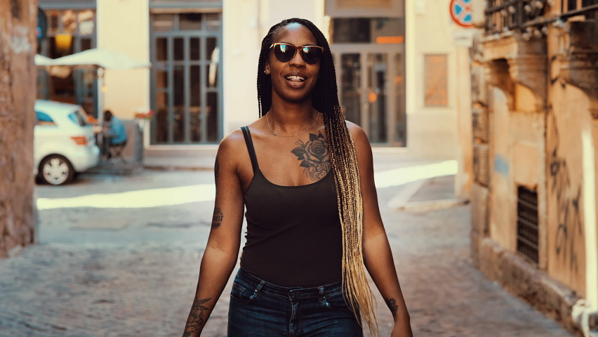 hispanic woman approaches the camera and steals the hat from the cameraman