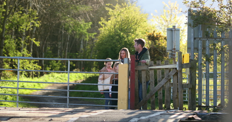 A front-view shot of a caucasian mother and father walking with their son and daughter, they