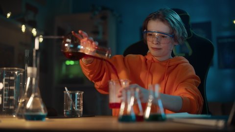Smart Young Boy in Safety Goggles Mixes Colorful Chemicals in Beakers at Home. Teenager Conducting Educational Science Hobby Experiments, Doing Interesting Biology Homework in His Room.