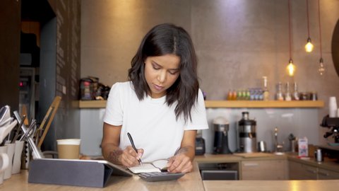 Worried coffee shop owner calculate business expenses