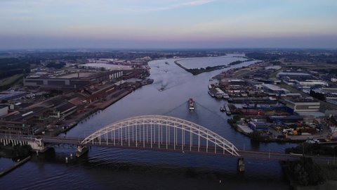 Sunset aerial view of bridge over the Noord with cargo ships passing by inland ports Alblasserdam Netherlands. 