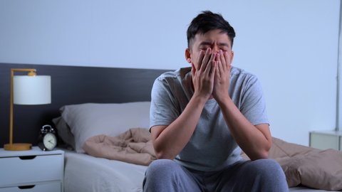Depressed young Asian man cannot sleep from insomnia. Depressed man suffering from insomnia.