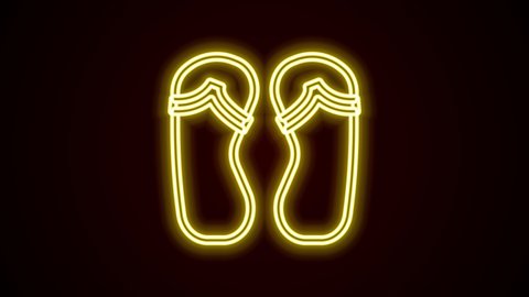 Glowing neon line Flip flops icon isolated on black background. Beach slippers sign. 4K Video motion graphic animation.