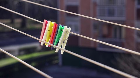 Close-up of colorful clothespins swaying in the wind against urban buildings