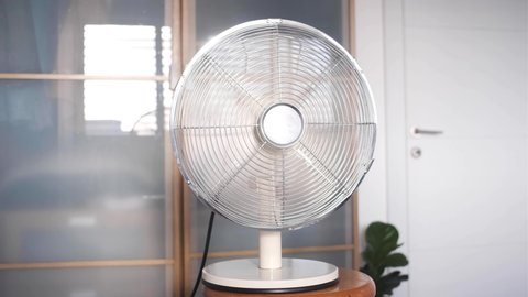 Electric air Ventilator blowing air. Close up of air fan.  electric fan Temperature Cooling the room. Electric Fan-Cooler wings speeding up  until getting to full speed. hot summer day in room no AC