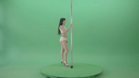White dressed Girl spinning down head on pole dance. Fit pole dancer girl in white underwear performing a rousing contemporary dance moves on pylon on green chromakey background.