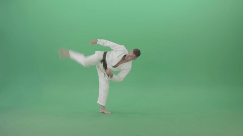 Mortal Kombat by Karate Jujitsu trainer sportsman. Man in white karate clothes training moves and kicks isolated on green background. Martial arts taekwondo training footage.