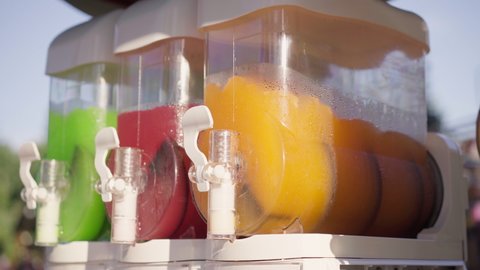 Machine Making Ice Slushy Drinks Outdoor Park Summer Red Orange Green Color. Iced Juice Mixer Machine Juicer Containing Smoothie Cocktail High quality 4k footage