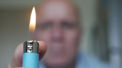 Shooting with a Person Lighting the Flame on a Cigarette Lighter.