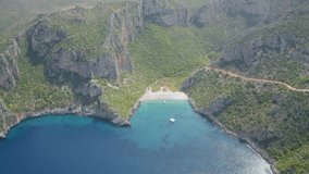 4K aerial - a bird's eye view video (Ultra High Definition) of Damos Beach. Green summer scene of Peloponnese peninsula, Greece, Europe. Bright morning seascape of Ionian sea.