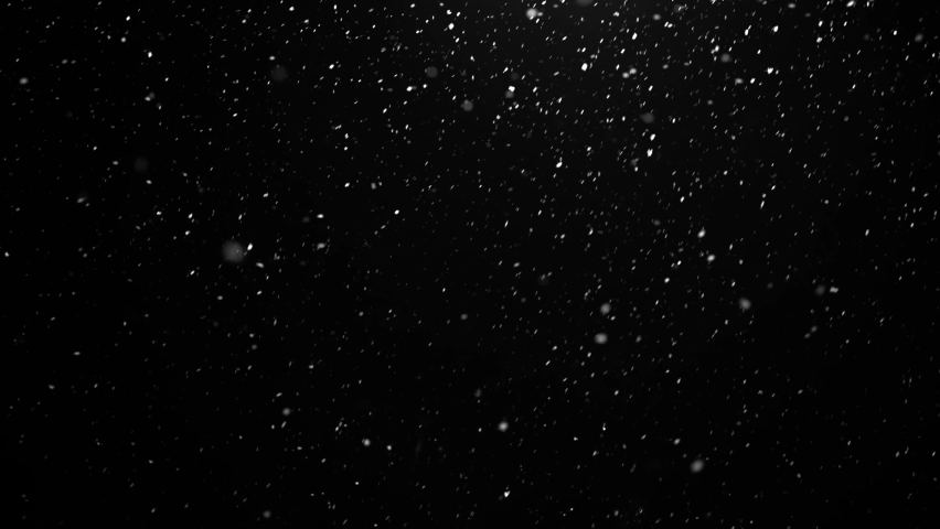 Snow falls in winter outside the window at night