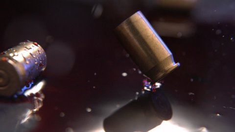 Bullet Casing Falling Into Blood At Crime Scene. Red Blood on Ground In Rain. Macro Of We Bullet Casing. Police Lights, Slow Motion