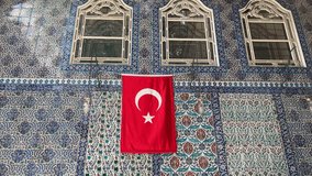 Wonderful interesting different different background image 4K video Tourism travel sightseeing vacation Turkey Istanbul hanging Turkish flag on Ottoman era tiles wall Ottoman architecture motifs.