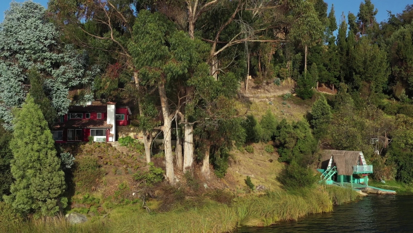 Laguna de Tota, Colombia. Drone Aerial View of Lakefront Houses, Beautiful Green Coastline and Serene Landscape on Sunny Day