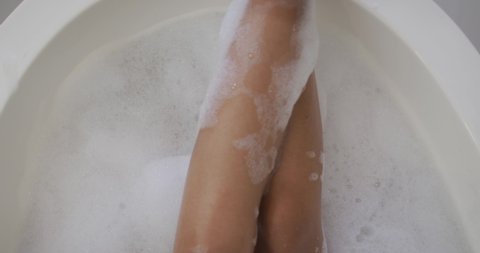 Mid section of mixed race woman taking a bath. domestic life, spending quality free time relaxing at home.
