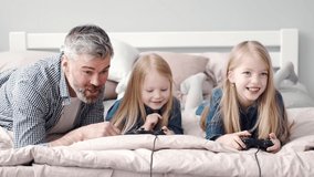 Two girls play video games with grandparent