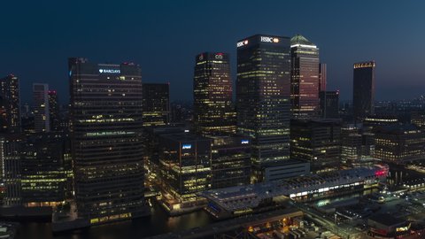 London, Great Britain - circa 2021 - Establishing Aerial View Shot of London UK, United Kingdom, Canary Wharf, Bussines District, Skyscrapers at night evening