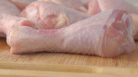 Fresh raw chicken drumsticks on a plate rotating.  raw chicken legs on a dish. Cooking food concept. Chicken parts close up footage. Fresh meat. Raw chicken legs for cooking.