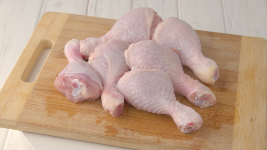 Fresh raw chicken drumsticks on a plate rotating.  raw chicken legs on a dish. Cooking food concept. Chicken parts close up footage. Fresh meat. Raw chicken legs for cooking. Royalty-Free Stock Footage #1075549781