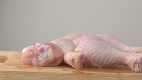 Fresh raw chicken drumsticks on a plate rotating.  raw chicken legs on a dish. Cooking food concept. Chicken parts close up footage. Fresh meat. Raw chicken legs for cooking.