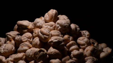 Chickpeas or garbanzos in a bowl gyrating on black background
