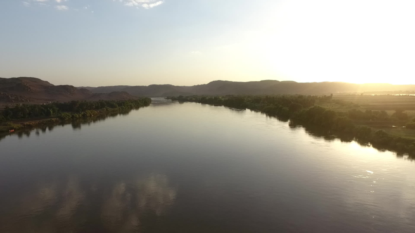 Aerial shot of sunset on the Nile River in Sudan, Drone Pulling Back Over the Nile River in Sudan Royalty-Free Stock Footage #1075555034