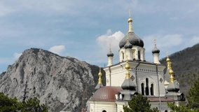 Foros church on top of mountain, Foros, Crimean peninsula. Fly over snow-white church with green domes on the top of mountain covered with dense greenery. Christian church on cliff over the Black Sea