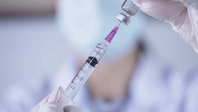 Medical nurse in safety gloves and protective mask using syringe suck Covid-19 out of bottle, preparation medication with sterile vials for mRNA vaccine, biotechnology and herd immunity building ideas - Powered by Shutterstock - Get 15% off with code: PIKWIZARD15