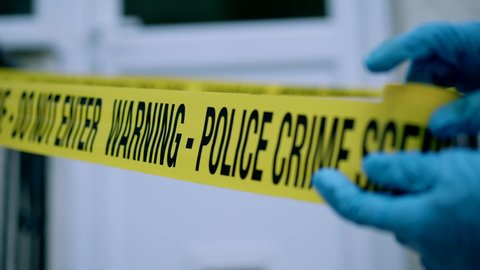 CSI Unravel Barricade Tape 'Do Not Cross' At Crime Scene Outside In Daytime
