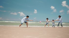Happy Asian family playing tug of war game on a beach during summer vacation. Parents and children pulling a rope and having fun together at the seaside. - Powered by Shutterstock - Get 15% off with code: PIKWIZARD15