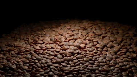 Mountain of lentils gyrating with intimate light on black background