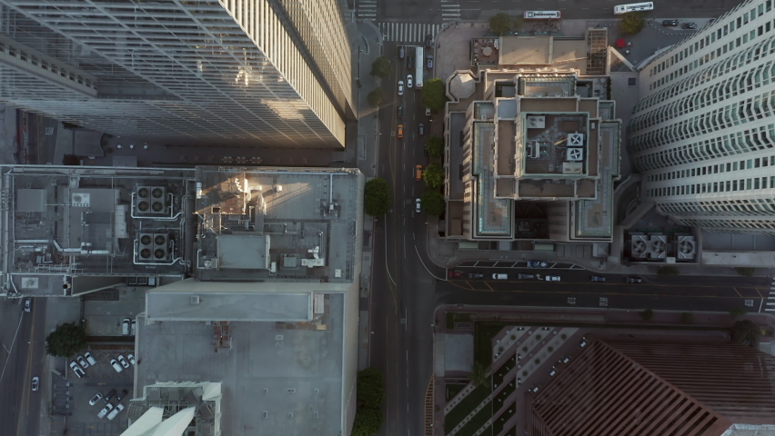 Passing by Huge Office Building Skyscraper Rooftops in Downtown Los Angeles, Aerial Birds Eye Overhead Top Down View of City Street with little Car traffic | Shutterstock HD Video #1075569692