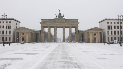 Snow falling at the Brandenburg Gate in the wintertime. Tourist hotspot in central Berlin.