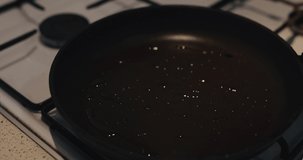 Puts the trout steak in the frying pan, video contains original audio