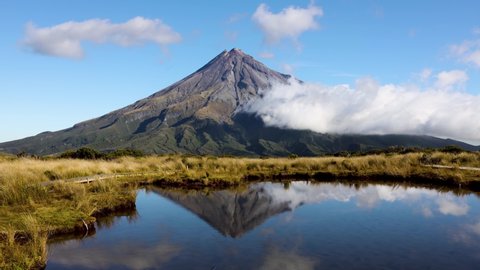 Tight shot time lapse of clouds rolling around Mount Taranaki. Shot with reflection from the Pouakai tarns on Mangorei track in New Plymouth, New Zealand