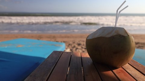 Whole coconut to drink. Indian ocean on background.
