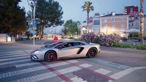 KOPER, SLOVENIA - JUNE 2021: Gray Lamborghini super car passing by on road at night 4K