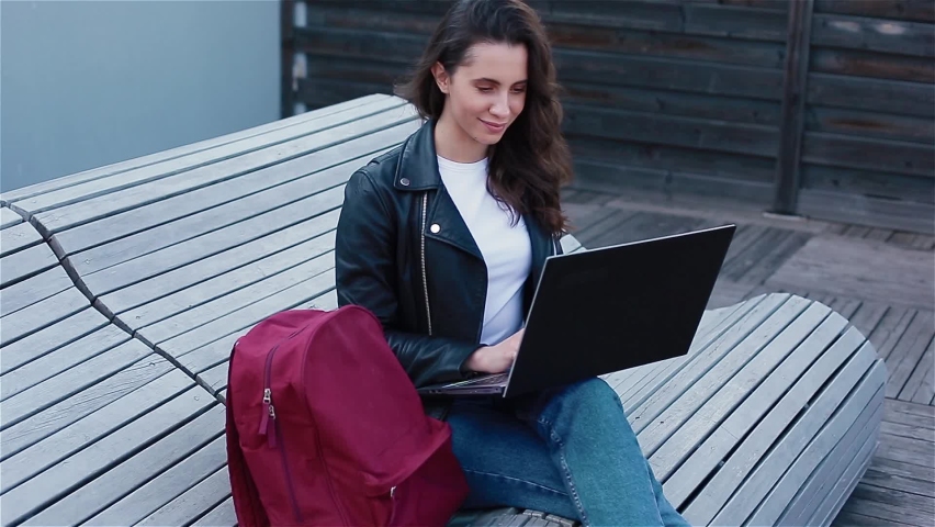 Young woman with laptop outside