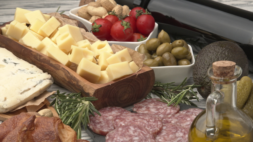 Huge assortment of various tasety spanish, french or italian apertizers. Cheese, meat, olives, stuffed peppers, bread, sticks. View from above. Assortment of spanish tapas or italian antipasti with me Royalty-Free Stock Footage #1075605782