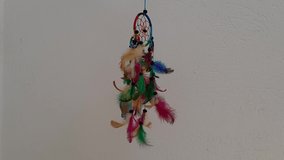 Rainbow Dream Catcher , Multicolor feathers of dreamcatcher hanging in front of a white wall