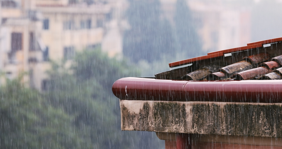 Close-up shot of heavy rain on the shingles and gutters of a roof in the city Royalty-Free Stock Footage #1075622504