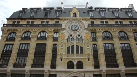 Unique Art Nouveau Facade Of A Building In Rue Reaumur, Paris, France With Ornate Clock On Exterior. low angle, slider right
