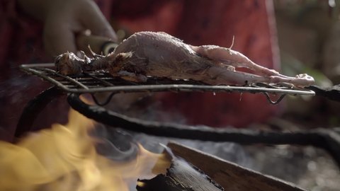Small quail bird is seared over outdoor open flame in Manipur, India