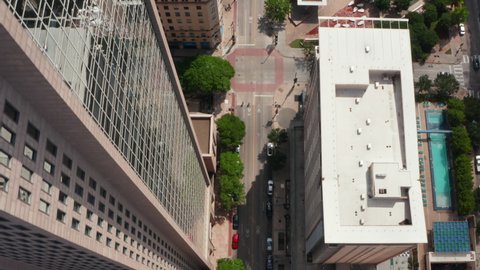 Aerial birds eye overhead top down panning view of downtown streets leading along public park. Dallas, Texas, US.