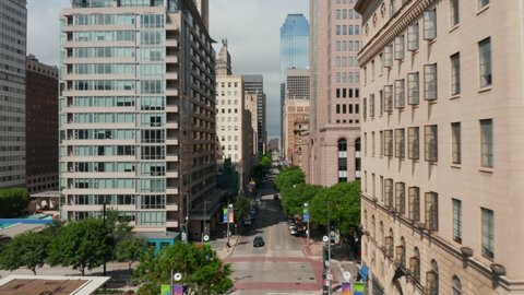 Forwards reveal of buildings along downtown street. Fly between various buildings. Dallas, Texas, US.