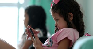 Little girl using smartphone at home. Child kid absorbed by screen